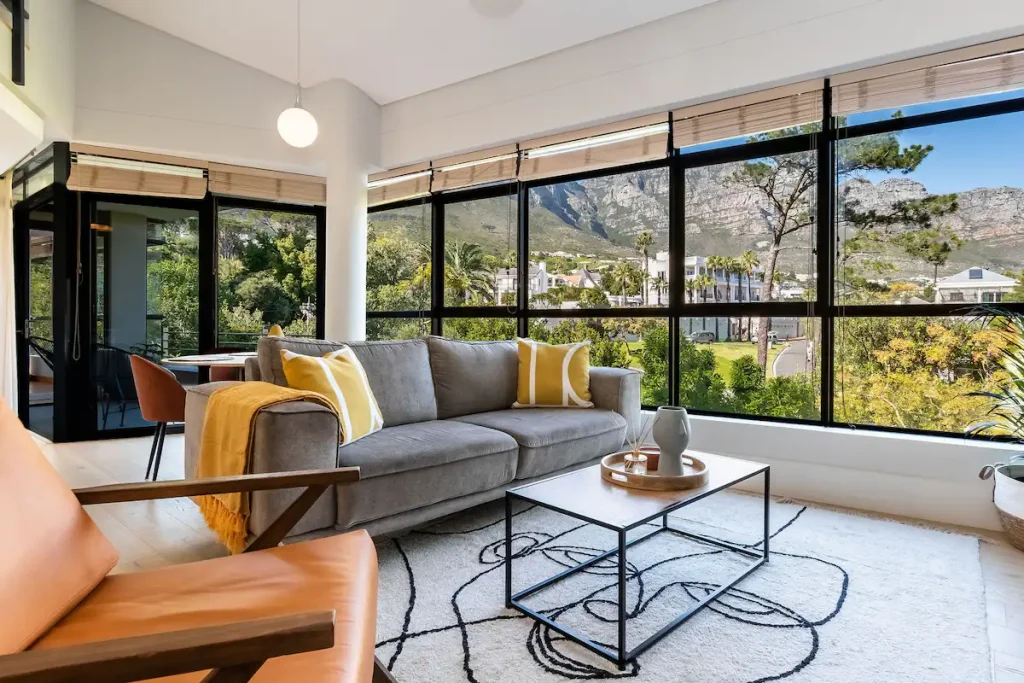 The living room at Mountain View Penthouse in Camps Bay, windows full of mountain